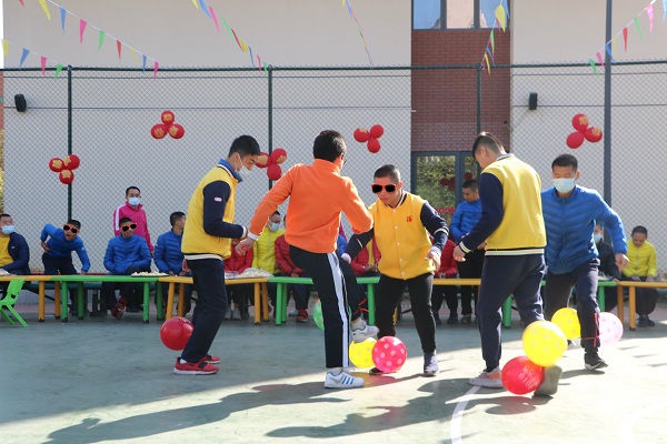 孩子们开心地玩着踩气球比赛，笑声欢呼声此起彼伏。.JPG